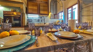 Comedor con una mesa lista para comer, con platos, vasos y un centro de mesa de limones.