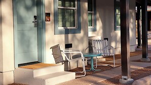 A building with a light blue door, a mailbox, and a bench outside. - The Dixie Motel Brenham (Brenham)