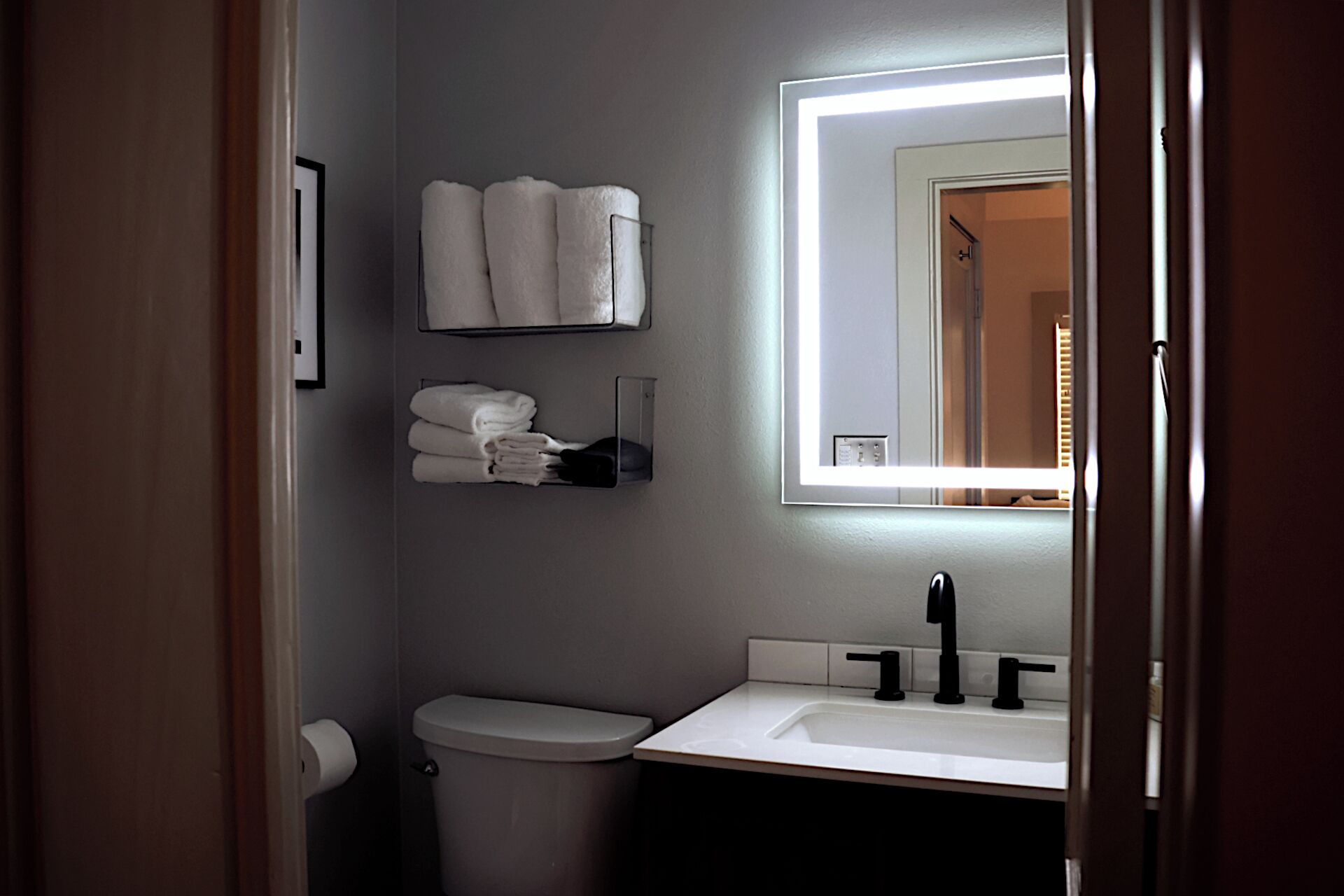 A bathroom with a toilet, sink, and towel rack.