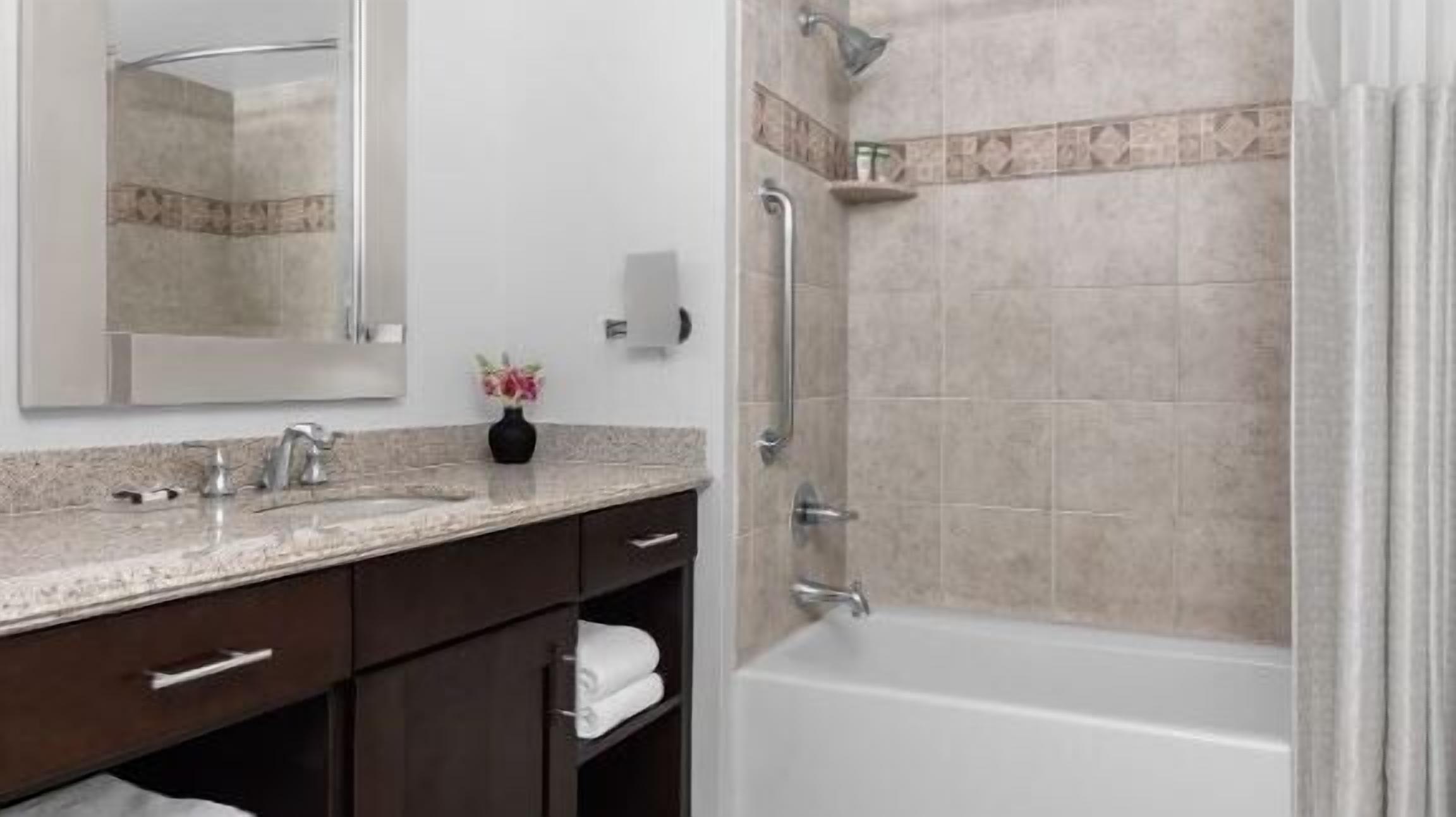 Une salle de bain moderne avec un meuble-lavabo, un évier et une douche.
