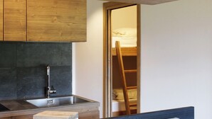 Una cocina compacta con un lavamanos moderno y armarios de madera.