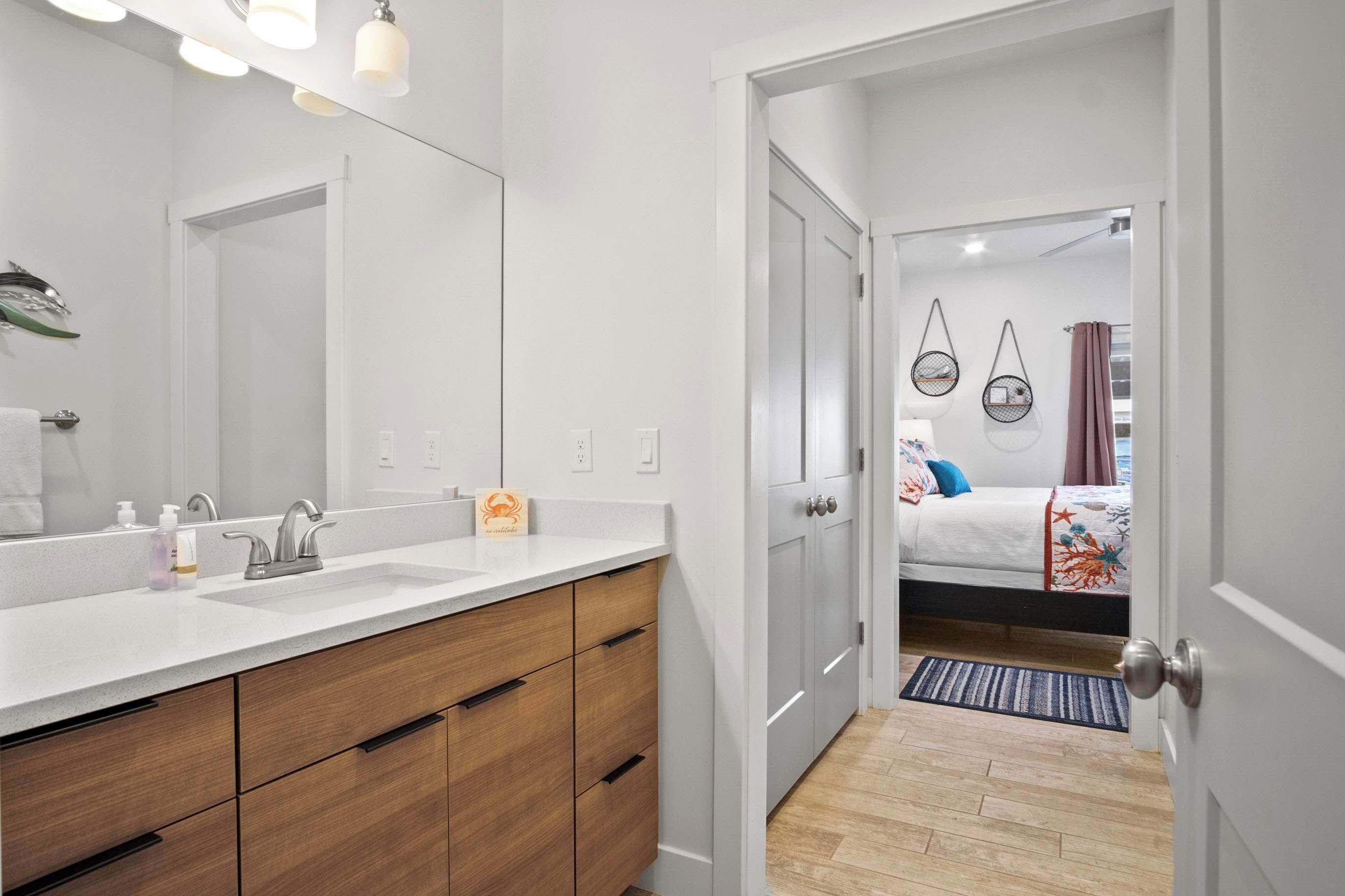 A modern bathroom with a large mirror, two sinks, and wooden cabinets.