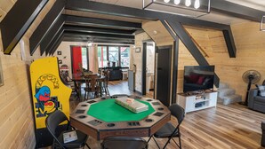 Un interior de madera acogedor, con varios niveles, que incluye un comedor, asientos y un televisor.