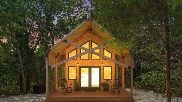 A wooden cabin with a porch, large windows, and a chimney. - Cedar Creek - Glamping in the Ozarks! (Walnut Shade)