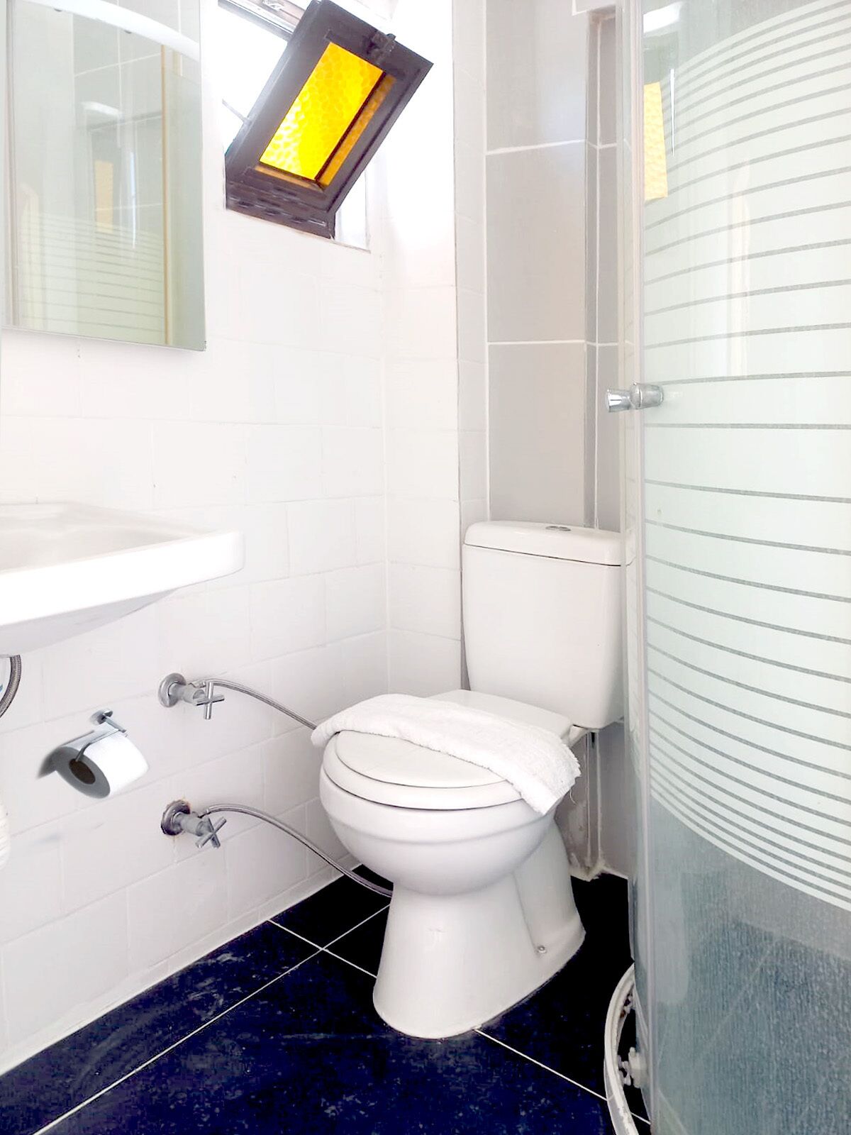 A bathroom with a white toilet, a white sink, and a mirror.