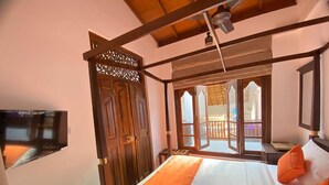 A bedroom with a bed, a TV, and a balcony with a view. - The Dutch Boutique (Galle)