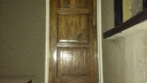 A wooden door with a white frame, leading to a staircase with black steps. - Christy Mwila Chisenga (Kitwe)