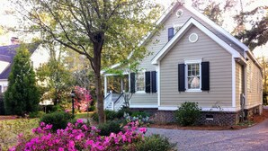 A single-story house with a porch, a brick foundation, and a driveway. - Home in Historic old downtown Summerville... (Summerville)