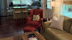 A living room with a sofa, armchair, and a coffee table with a tray. - Home in Historic old downtown Summerville... (Summerville)