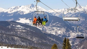 Un télésiège avec des skieurs portant des vestes aux couleurs vives.
