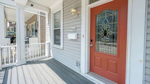 A house with a red door, white porch, and a mailbox. - Cityscape Escape (Cincinnati)