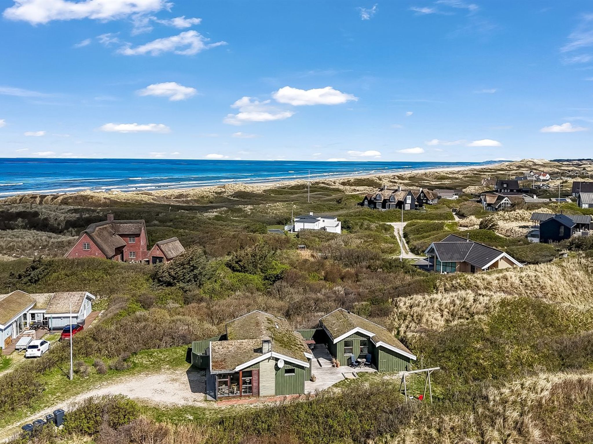 A coastal village with traditional houses, a sandy beach, and a clear view of the ocean.