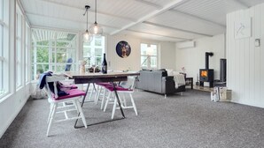 A spacious living area with a dining table, chairs, a sofa, and a fireplace. - "Gunward" - 1.5km from the sea by Interhome (Sæby)