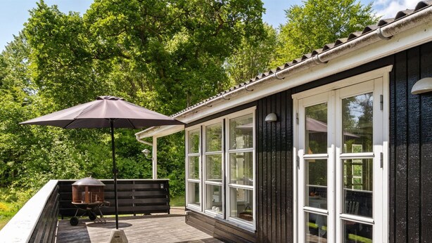 A wooden deck with a grill, a table, and an umbrella. - "Gunward" - 1.5km from the sea by Interhome (Sæby)