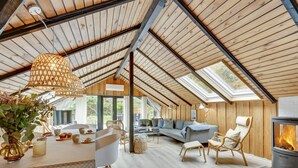 A spacious loft with a high ceiling, wooden beams, a cozy seating area with a sofa and chairs, a dining table with chairs, and a fireplace. - "Sidse" - 400m from the sea by Interhome (Ringkøbing)