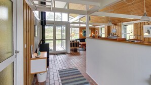 A modern kitchen with a wooden ceiling, a dining area with a bench, and a large window providing natural light. - "Alin" - 600m from the sea by Interhome (Oksbøl)