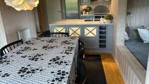 Une cuisine compacte avec un îlot central, un coin repas doté d’une table à motifs et un espace nuit confortable avec un lit.