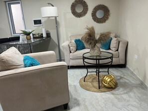 Un salon comprenant un canapé, une table basse et des objets de décoration.