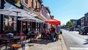 Un café avec terrasse, des tables et des parasols.
