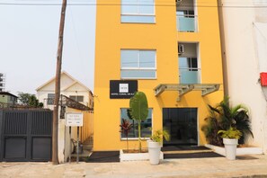 A yellow building with a sign for "Hotel Coral da Ilha." - Hotel Coral da Ilha (Luanda)