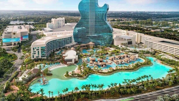 A resort with a guitar-shaped building, multiple swimming pools, and lush landscaping. - Private Parking + Own Patio
+ FREE Bikes 1b/1b Apt (Hollywood)
