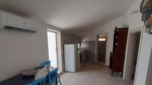 Een ruime keuken met een eethoek, een koelkast en een houten kast.