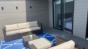 A patio with a sofa, two armchairs, a small table, and a patterned rug. - Minutes To The Falls:  Stylish Townhome Gem! (Niagara Falls)