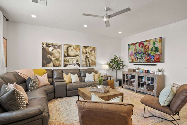 A modern living room with a sectional sofa, a coffee table, and a cabinet with glass doors.