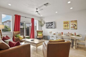 A living room with a sofa, armchairs, a dining table, and a ceiling fan. - Live in Fantasy at Disney in the Desert! (Washington)