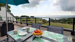 Ein Balkon mit Frühstückstisch und Blick auf das Meer, sowie das Logo von Gîtes de France.