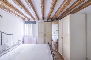 A bedroom with a wooden ceiling, a bed, a wardrobe, and a window. - Ca' Gamba, a quite typical space in Venice (Venezia)