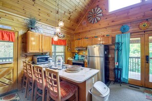 Enjoy cooking and dining in this cabin-style kitchen with a central island, refrigerator, microwave, toaster, and sink.