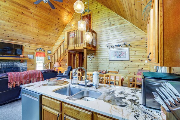 Cozy cabin with a living area, fireplace, kitchen, and dining space.