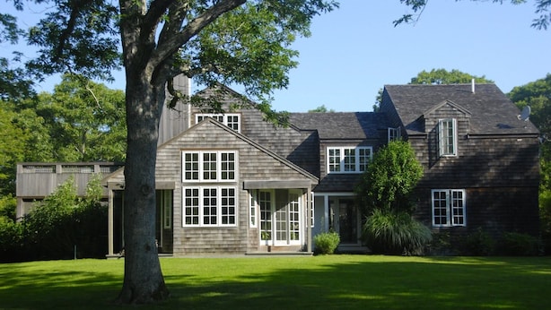 A two-story house with a large front lawn, a prominent tree, and a satellite dish. - Spacious and gracious architect designed home on 3 acres off Middle Road. (Chilmark)