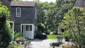 A backyard with a patio, outdoor furniture, and a grill. - Spacious and gracious architect designed home on 3 acres off Middle Road. (Chilmark)
