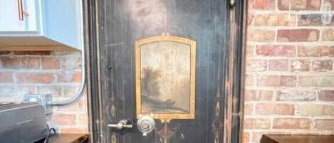 Une porte en bois sombre, dotée d’une poignée en laiton et d’une petite plaque en laiton portant l’inscription « Detroit Safe ».