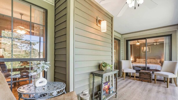 A cozy room with a large window, a small table with decorative items, and a comfortable seating area with chairs. - Golf View Peek-a-boo (Branson)