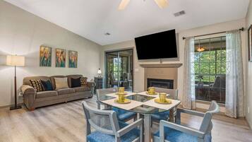 A living room with a sofa, a coffee table, and a fireplace.