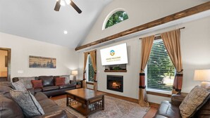 A living room with a fireplace, leather sofas, a coffee table, and a television.