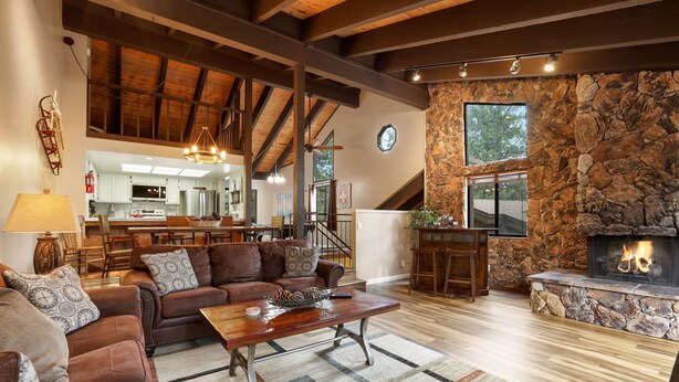 A spacious living room with a stone fireplace, wooden ceiling beams, and a cozy seating area. - Heavenly Haven - Hot Tub + Seasonal HOA Pool (Zephyr Cove)