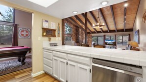A modern kitchen with white cabinets, a stainless steel dishwasher, and a wooden ceiling. - Heavenly Haven - Hot Tub + Seasonal HOA Pool (Zephyr Cove)