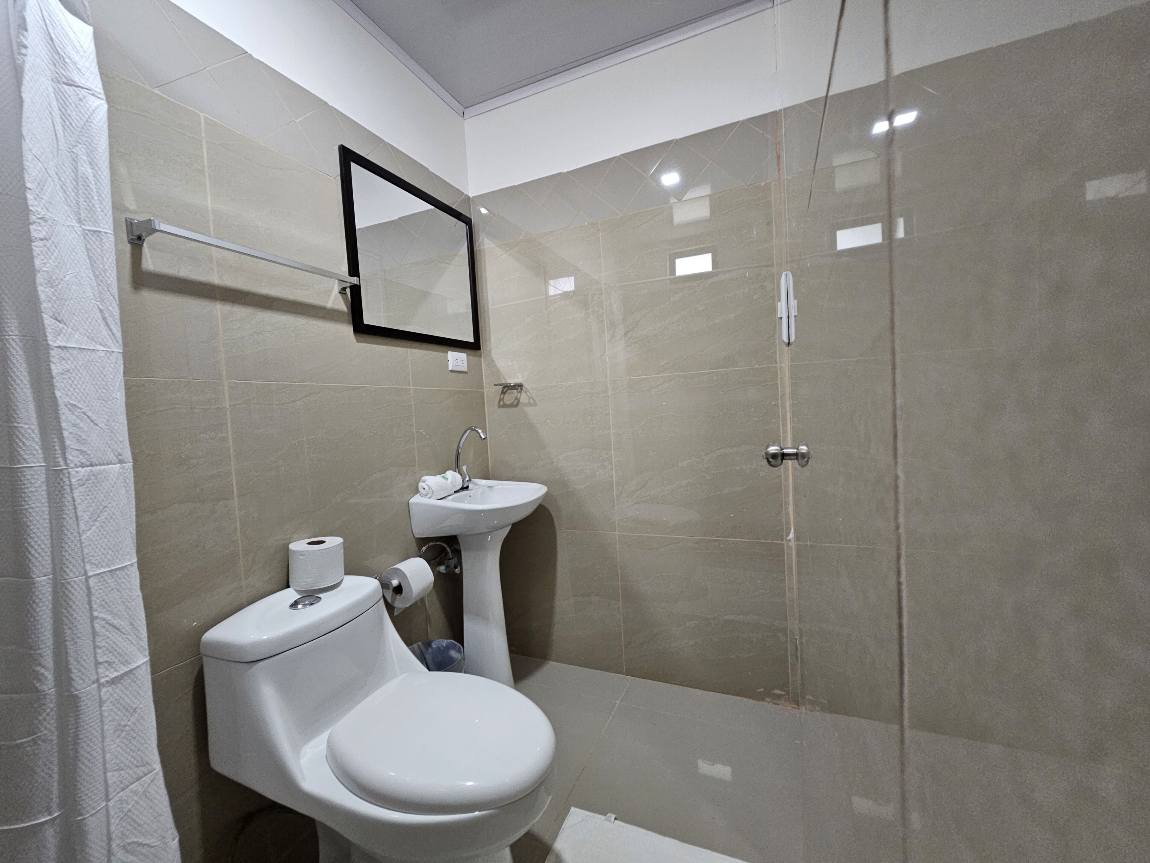 Un bagno moderno con servizi igienici, lavandino e box doccia in vetro.