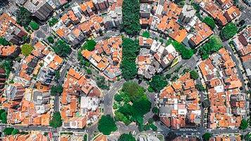 Vue aérienne d’un quartier résidentiel caractérisé par des maisons très rapprochées les unes des autres, des rues étroites et des espaces verts.
