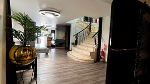 Un vaste espace de vie doté d’un plancher en bois, d’un escalier et d’un luminaire moderne.