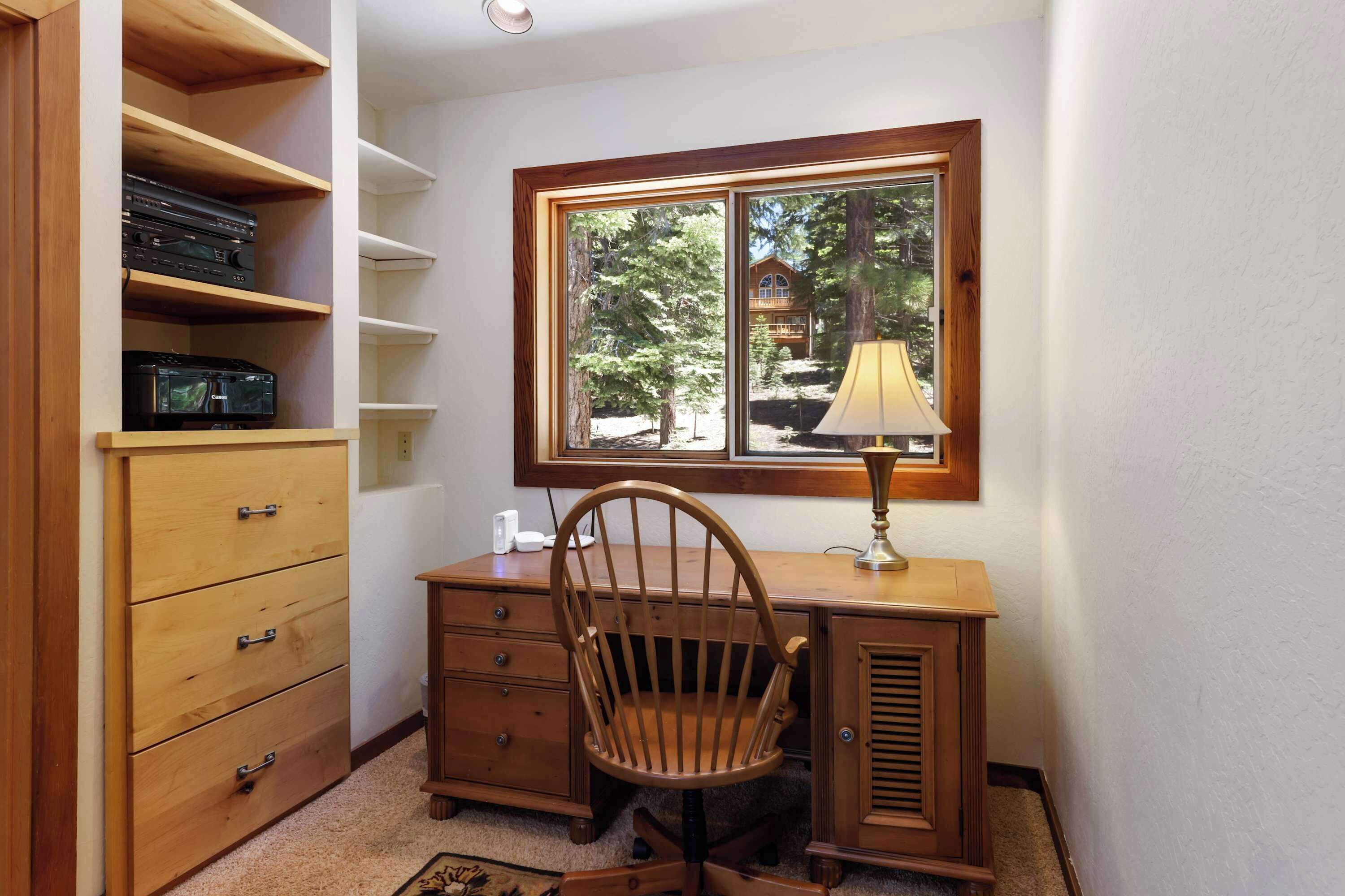 Een hoekappartement met een houten bureau, stoel en een plankenunit.