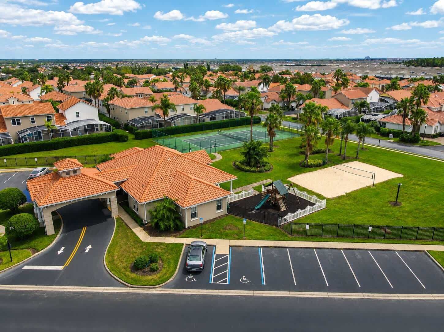A residential area with houses, a tennis court, and a parking lot.