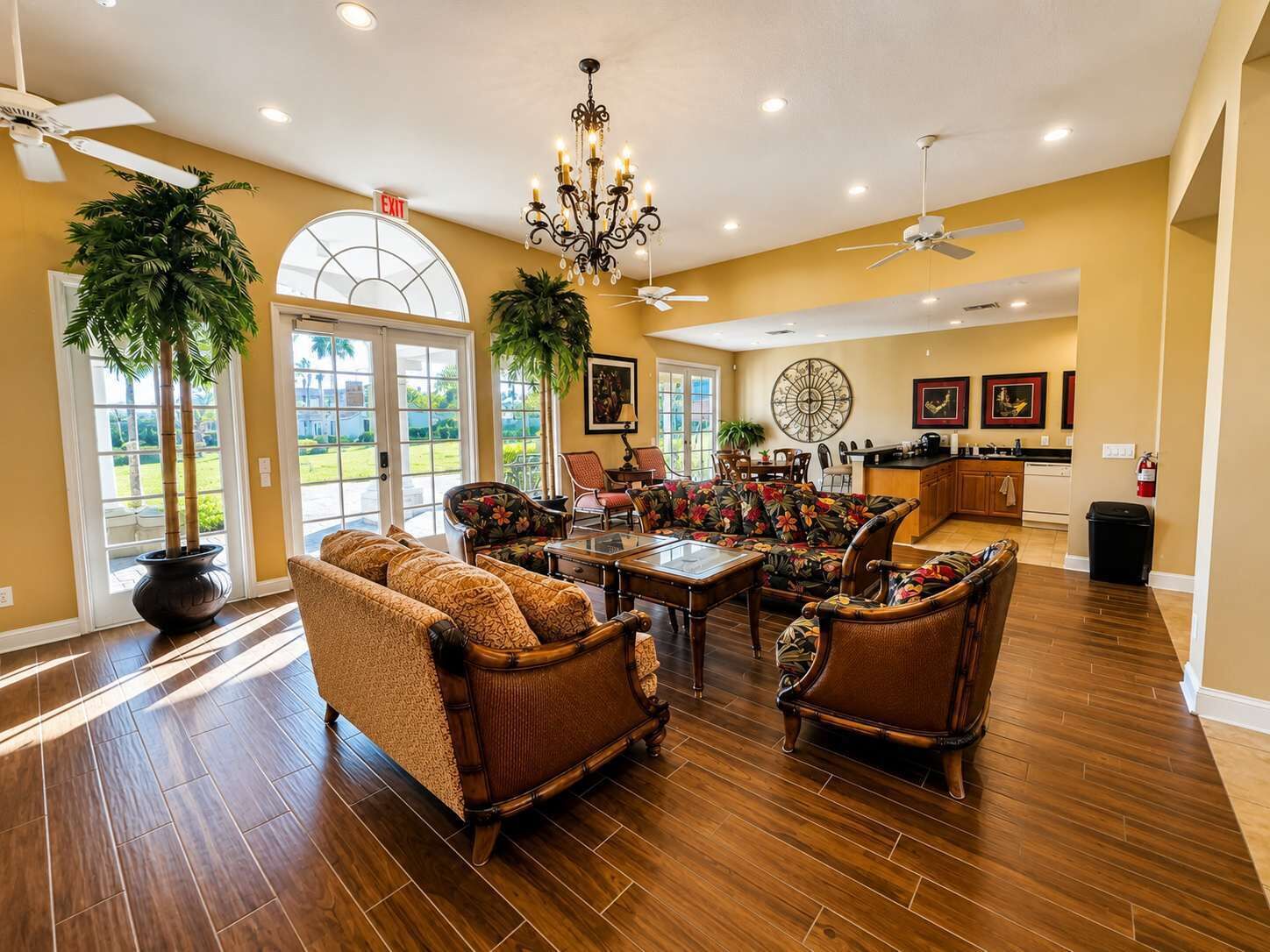 A spacious living room with a large dining table, comfortable seating, and a view of the outdoors through a glass door.