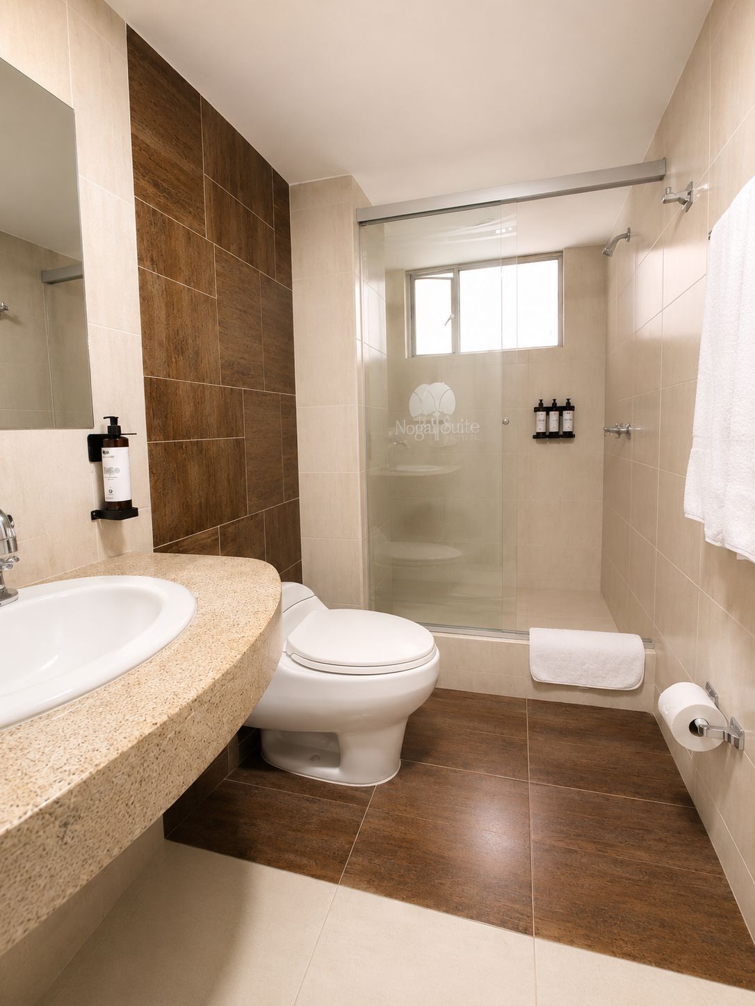 Un baño moderno con ducha, inodoro y lavamanos.