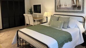 Un dormitorio ordenado con una cama, un escritorio y una silla.