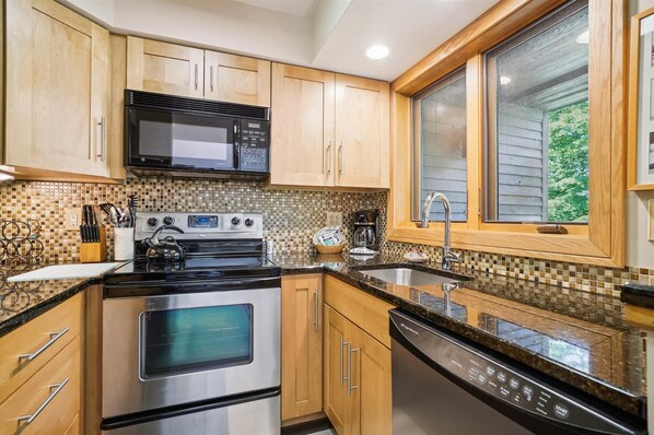 Enjoy cooking in this kitchen with a central island, stove, oven, microwave, and coffee maker.